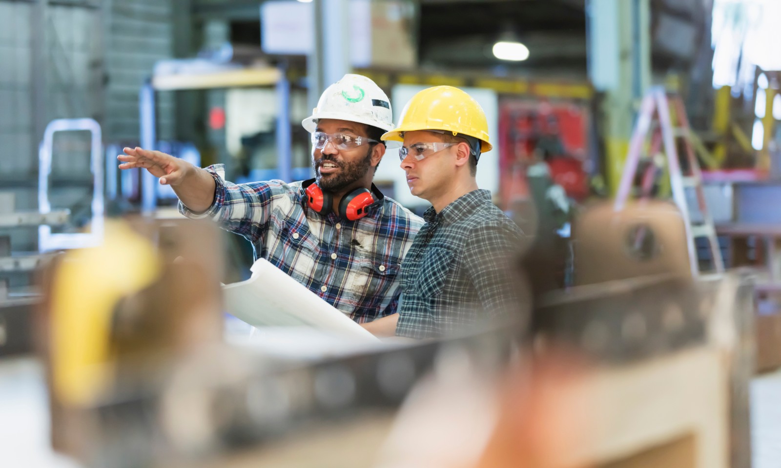 Two middle-aged factory workers in factory using commercial natural gas services.